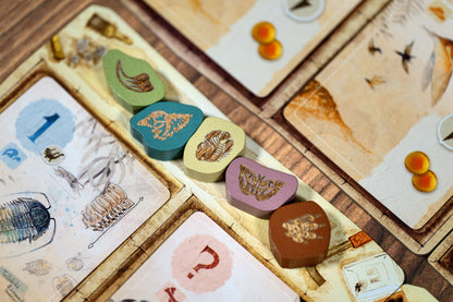 Close-up of a board game with cards and game pieces on a wooden surface