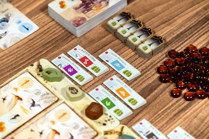 Board game components including cards and dice on a wooden surface